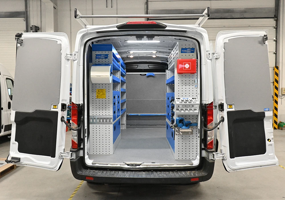 Rear view of Ford Transit 148 medium-roof plumber van shelving with dual-side storage, drawers, parts bins, and a pull-out vise