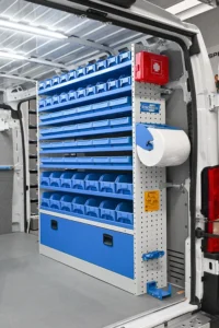RAM ProMaster plumber van shelving with full-height parts bins, first-aid kit, paper-roll holder, and lower cabinet