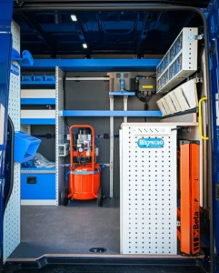 Side-door view of Sprinter mobile mechanic van with compressor, workbench, drawers, and equipment storage