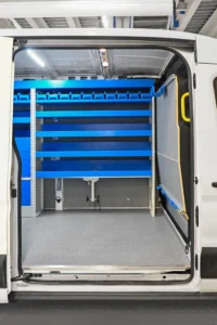 Side-door view of Ford Transit 148 medium-roof plumber van shelving with long shelves, upper parts bins, and open cargo floor