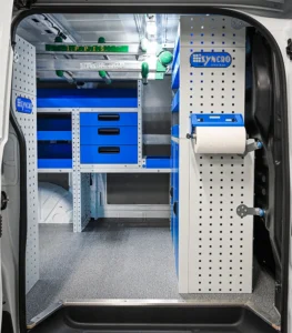 Side-door view of electrician van shelving with front drawers, open shelves, paper-roll holder, and overhead storage