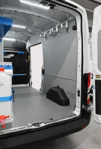 Ford Transit electrician work van with open passenger-side cargo space beside the shelving package