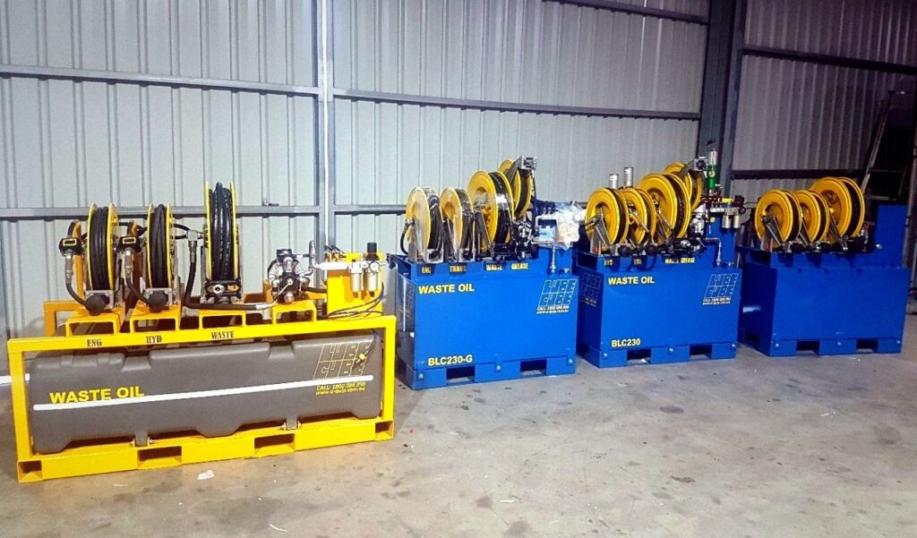 MecLube equipment set up on multiple lube skid units lined up in a shop, including waste oil systems, hose reels, pumps, and lubricant service equipment.