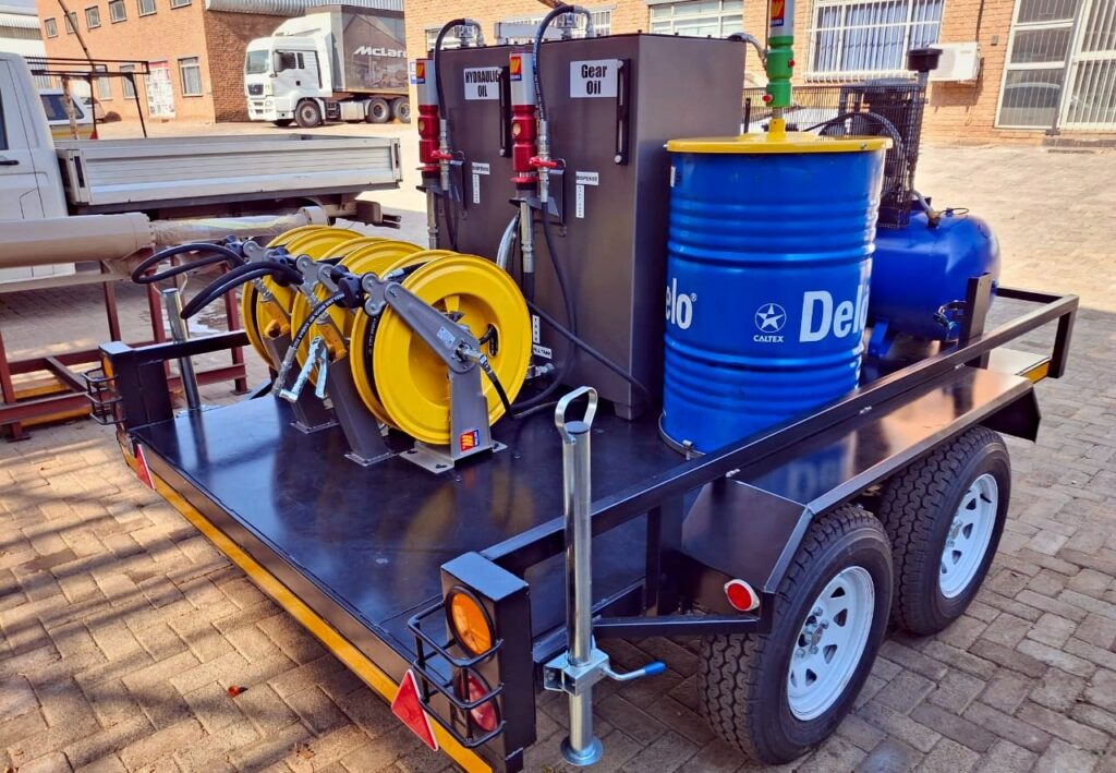 MecLube set up of a Dual-axle lube trailer with waste oil storage, yellow hose reels, lubricant pumps, and fluid dispensing equipment
